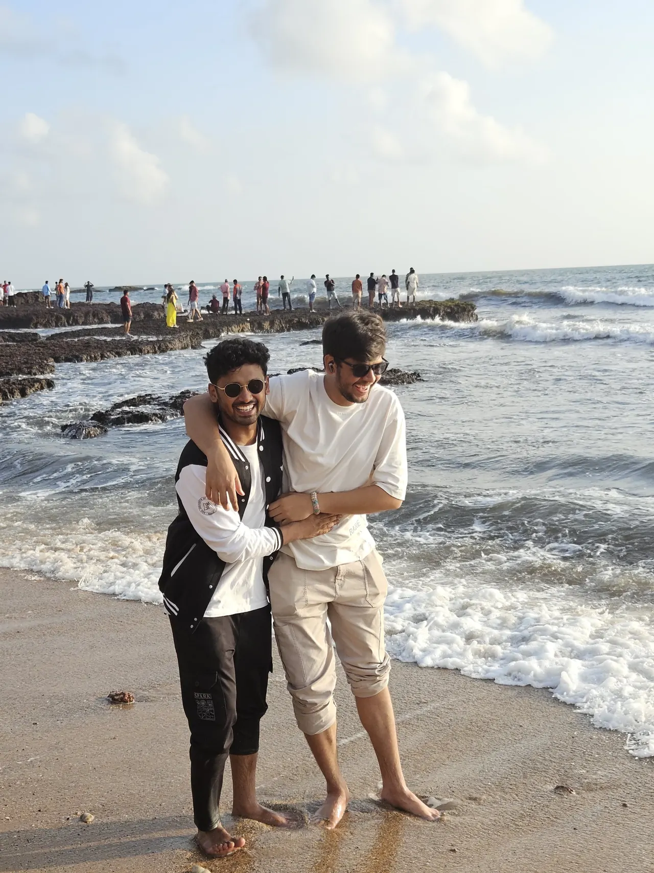 Aditya and his friend Aman on a rocky beach, arms around each other