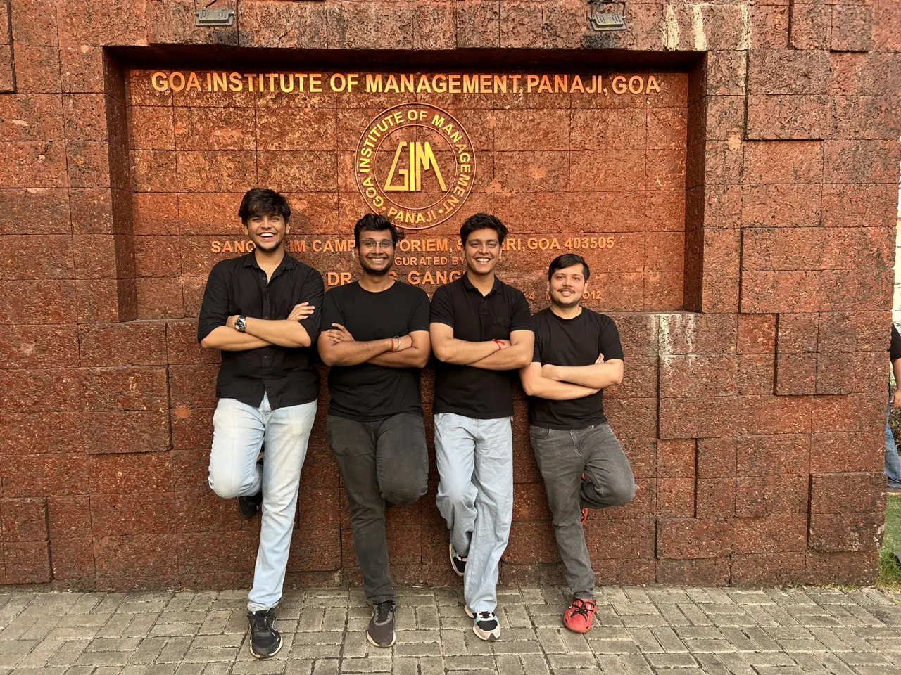 Aditya with Nikhil, Deep and Aman Agasthya in front of the Goa Institute of Management sign