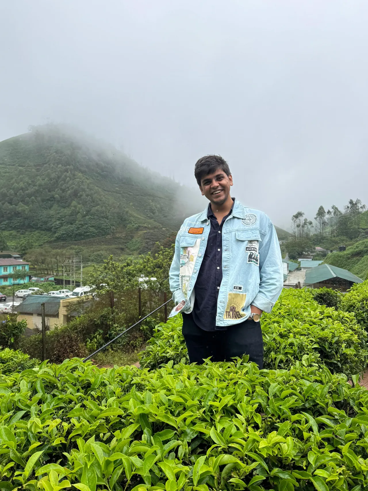 Aditya in a denim jacket among tea bushes in misty Munnar